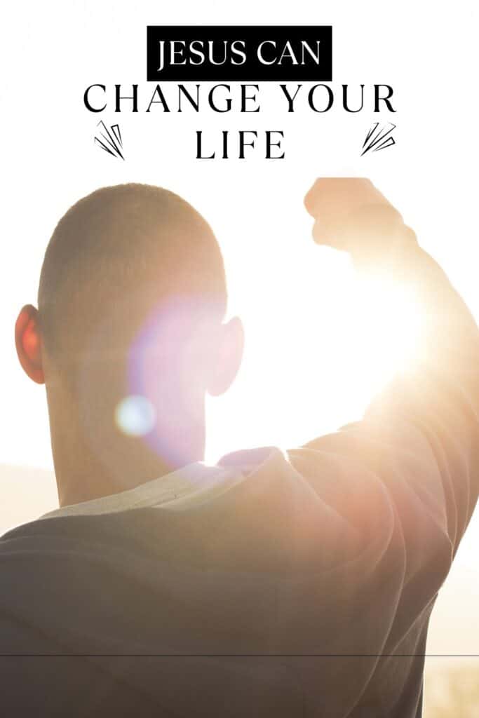 Man standing in front of light with fist raised