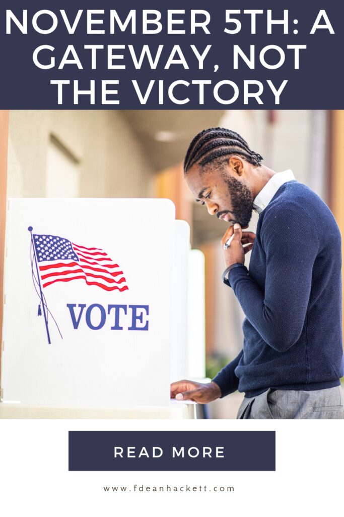 Man in blue sweater standing at a voting booth