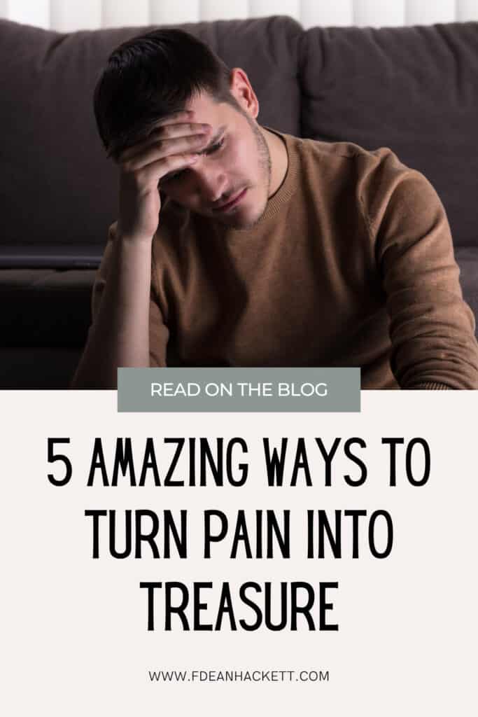 Man sitting in front of brown couch sad and holding head in his hands