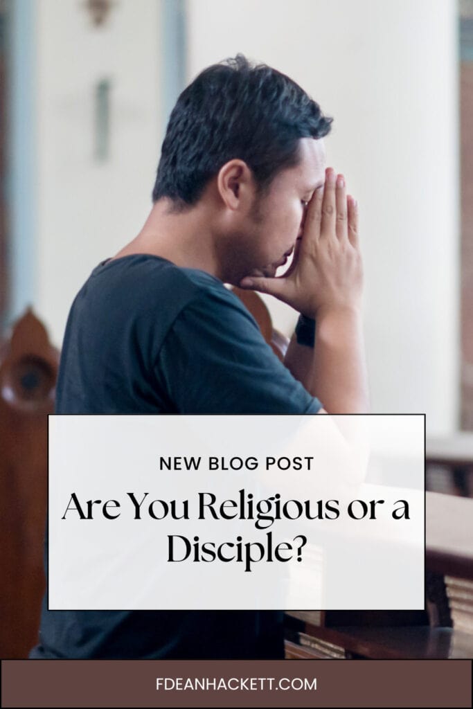 Man kneeling in a church praying with hands folded